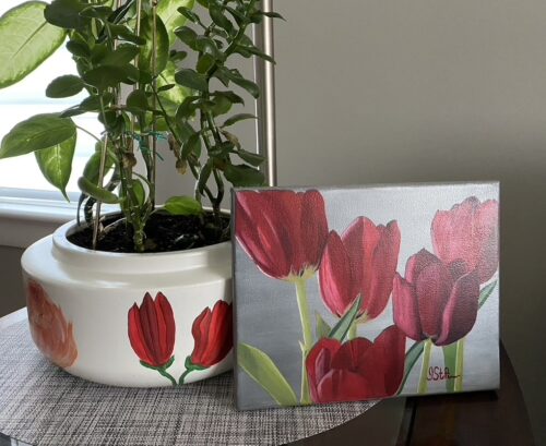 Close up painting of 5 red tulips beside a potted plant