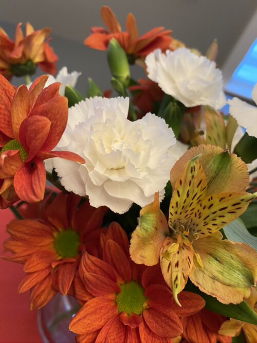 Photo of a red, orange and white flower arrangement