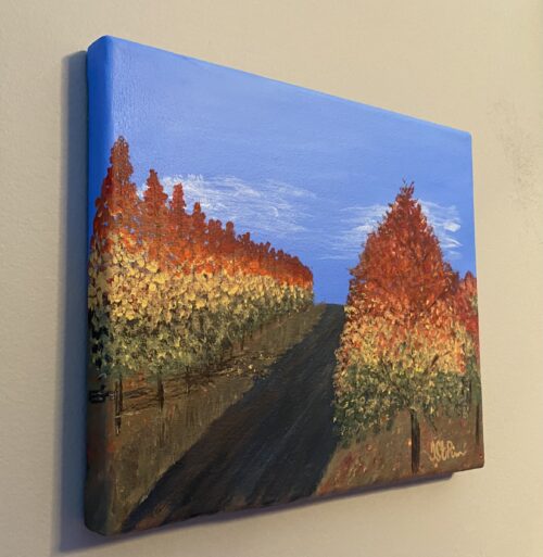 Painting of a road lined with colorful autumn trees on both sides