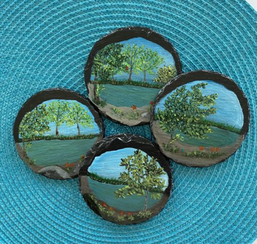 Set of 4 coasters painted with images of a pond and trees