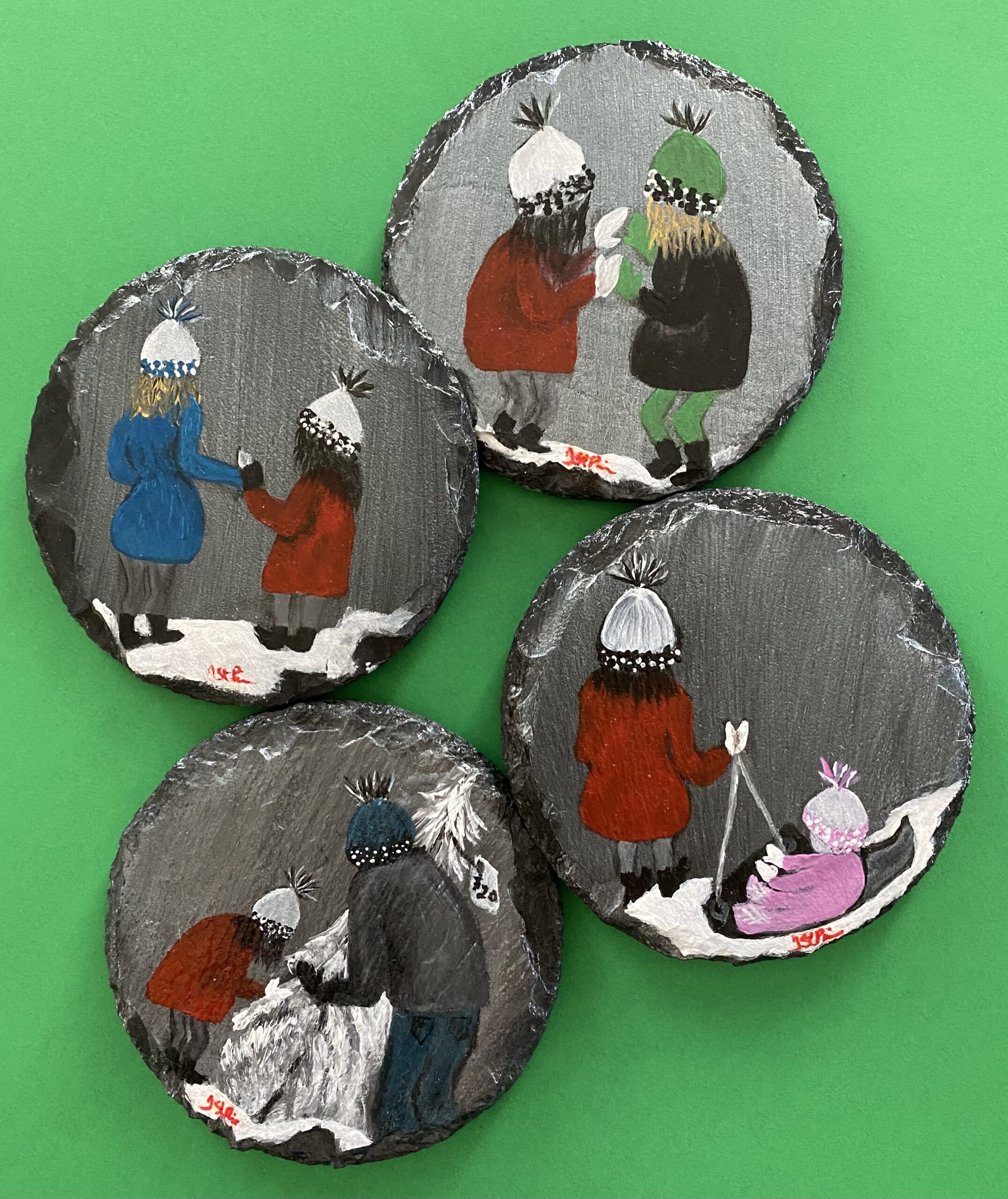 Set of 4 coasters painted with images of a girl and her family on them.