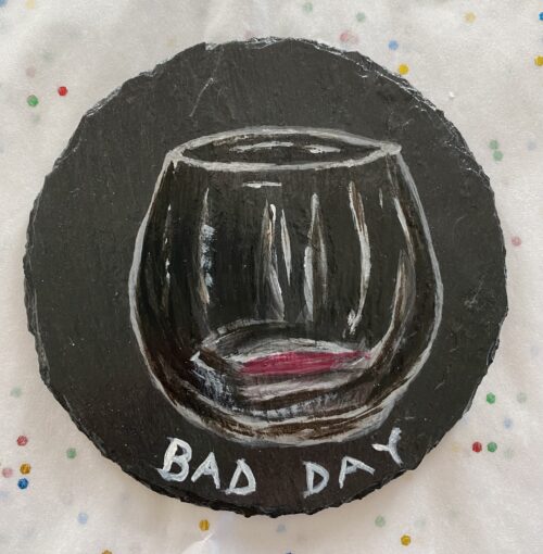 Coaster painted with an empty glass of wine on it