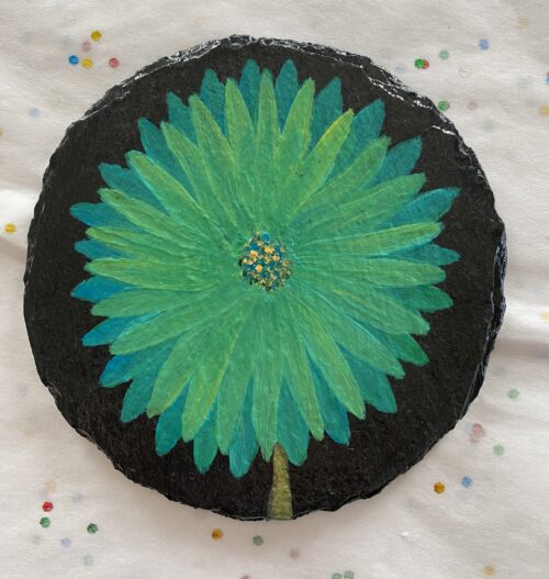 Coaster with a green flower painted on it