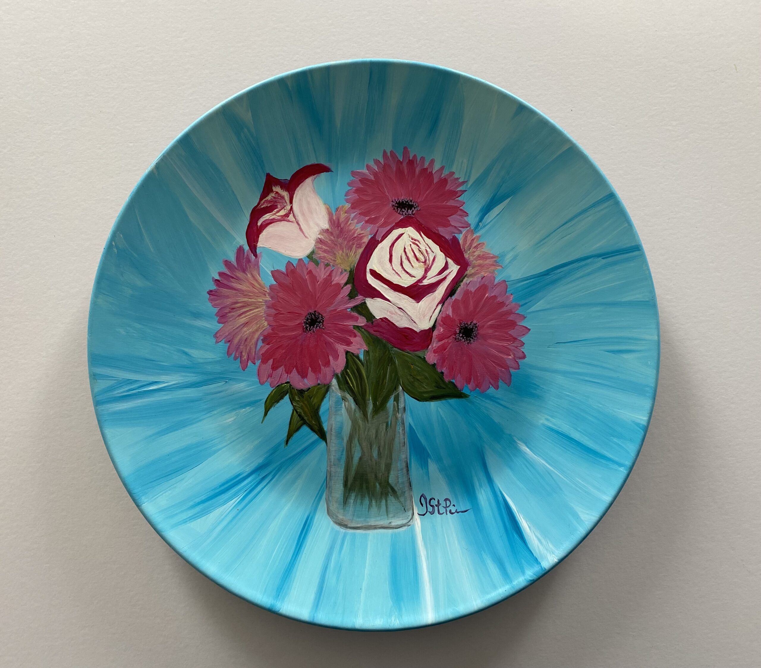 Photo of a Turquoise plate hand painted with Pink Roses and Gerbera Daisies in a glass vase