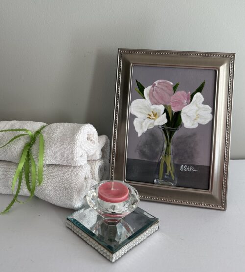 A small painting of pink and white tulips in a clear carafe