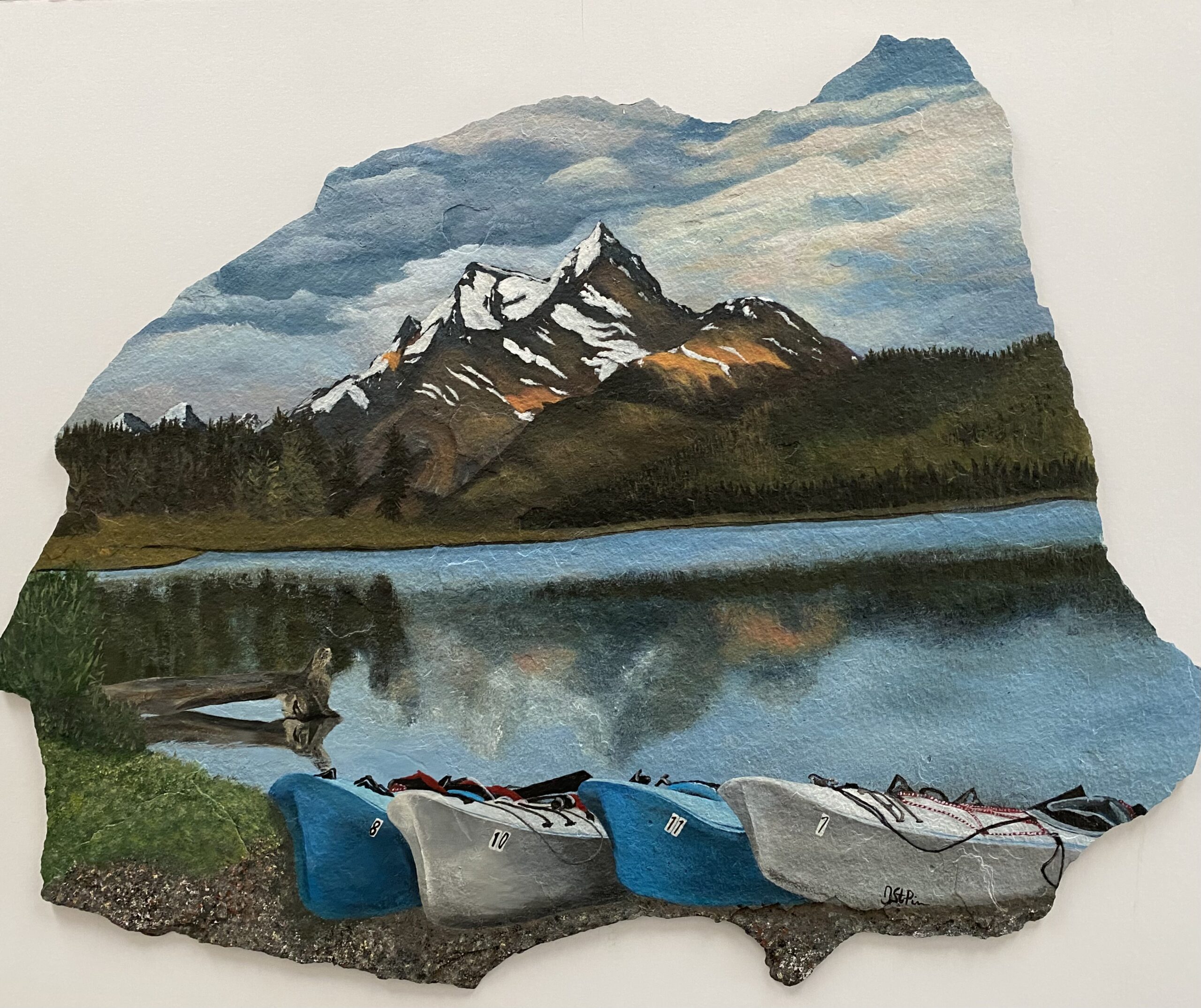 A photo of a large piece of slate stone, hand painted with a mountain and water scene