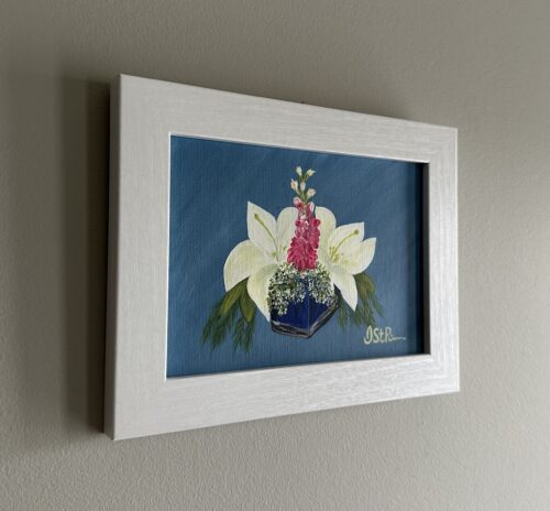 A painting of white lilies in a blue glass vase in a white frame