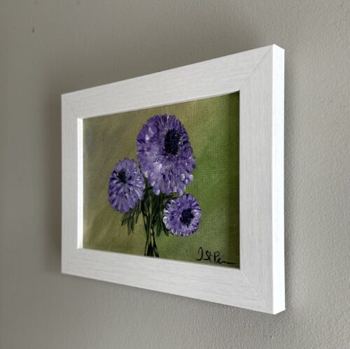 A painting of purple Chrysanthemums on a green background and in a white frame