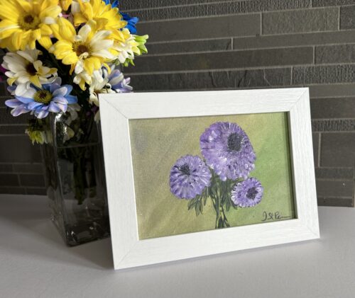 A painting of purple Chrysanthemums on a green background and in a white frame